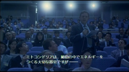 An audience member at a talk before Asakura’s stands up and asks a series of questions. It looks as though he is reading the script